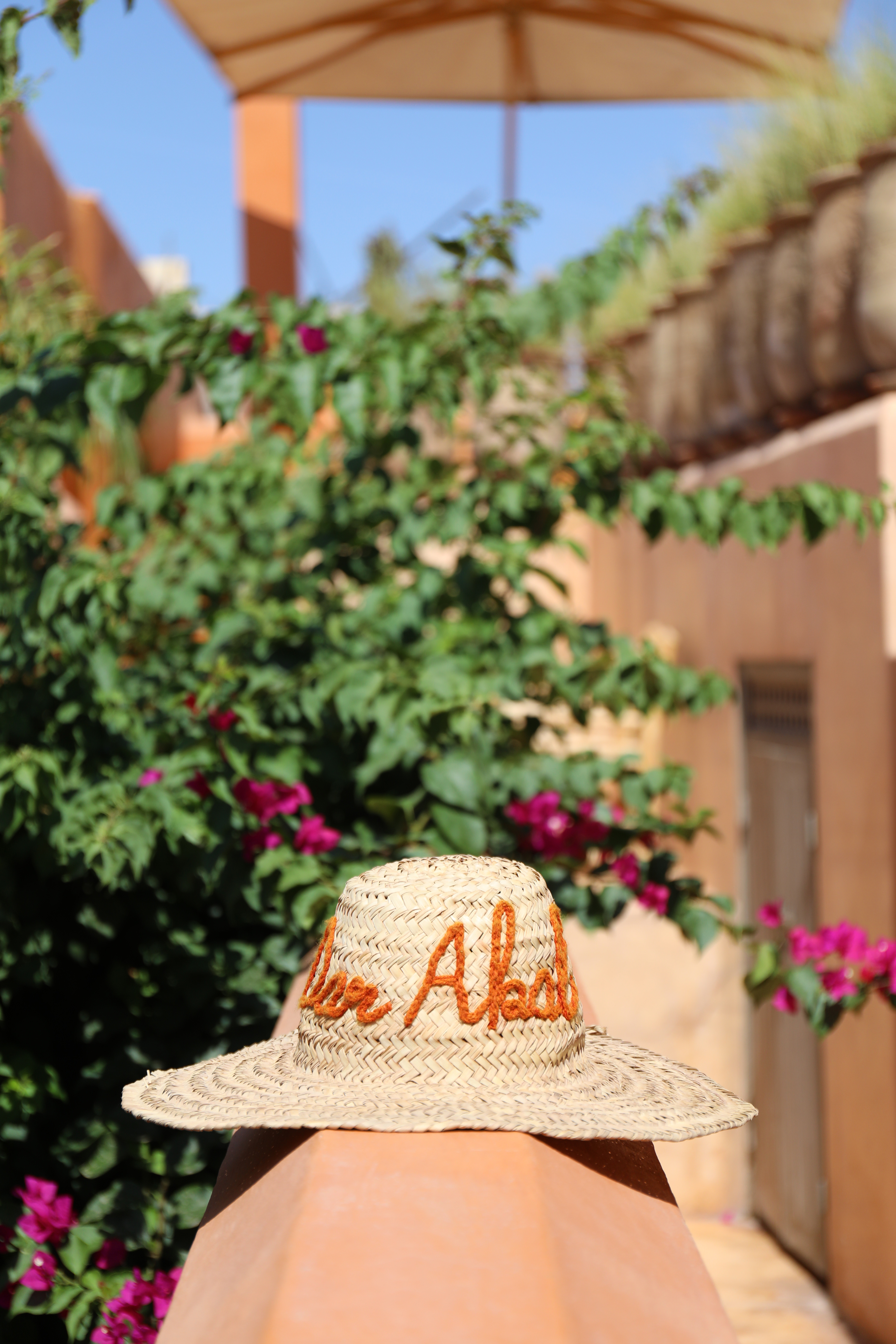 Un chapeau tressé Dar Akal parmi les bougainvilliers du toit-terrasse