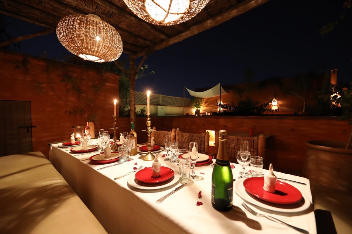 Une longue table dressée aux chandelles sur le toit du Dar Akal, la nuit
