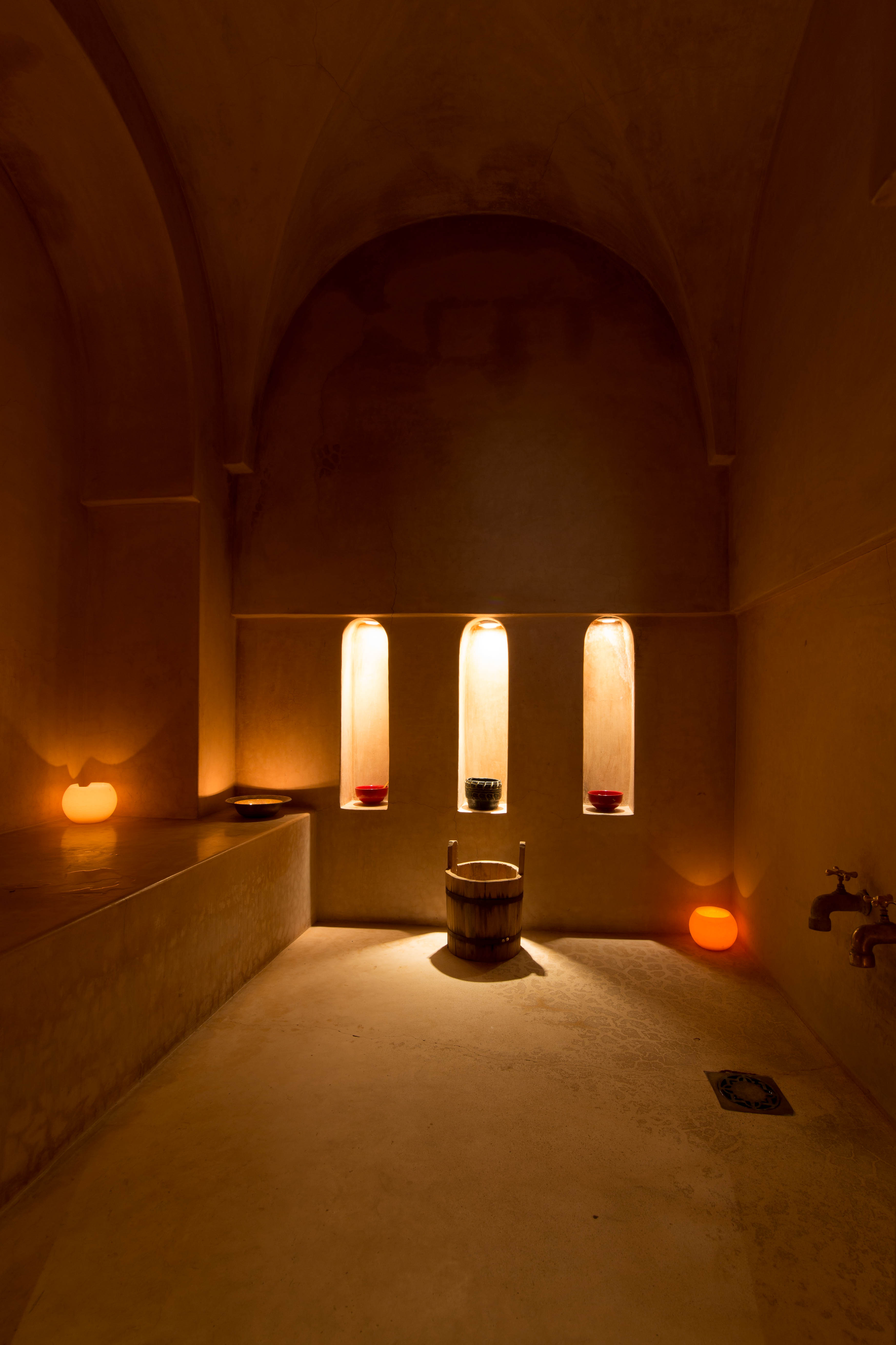 The candlelit tadelakt interior of the hammam at Dar Akal