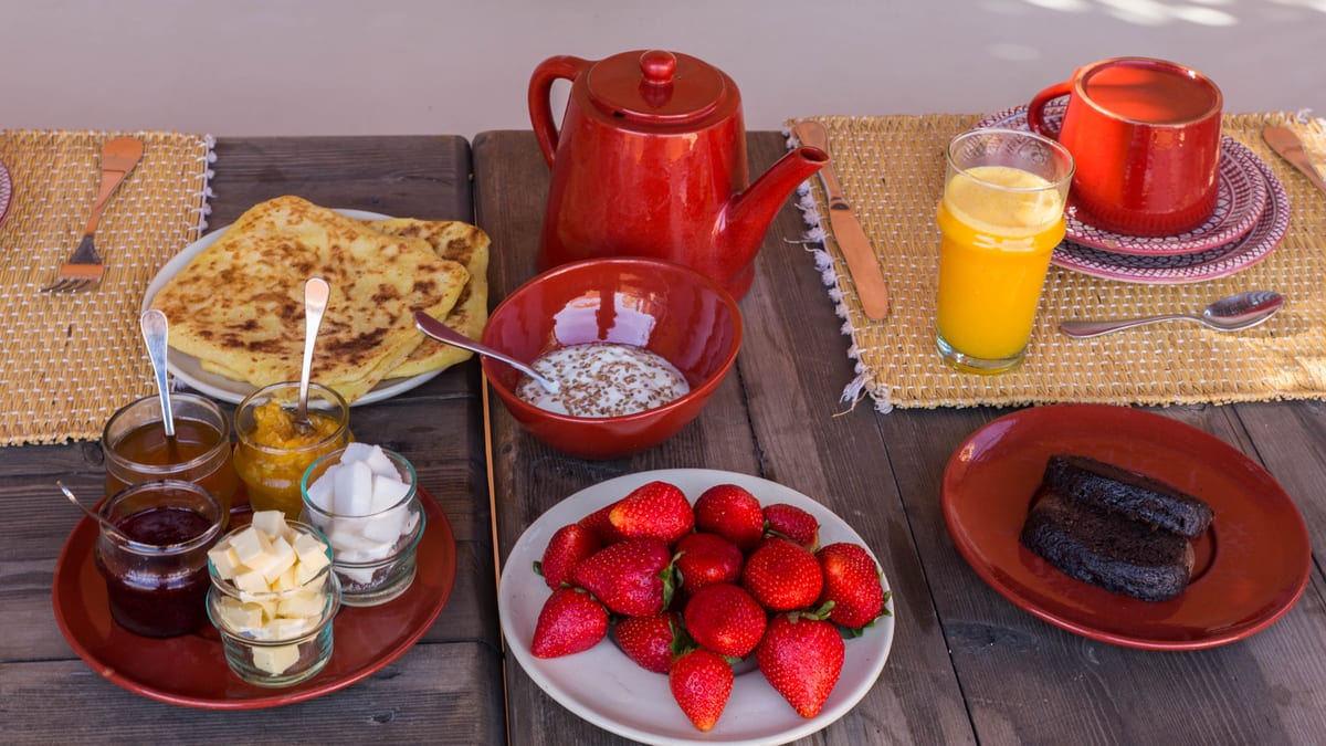 A Moroccan breakfast with tea, msemen, fruit and fresh orange juice at Dar Akal