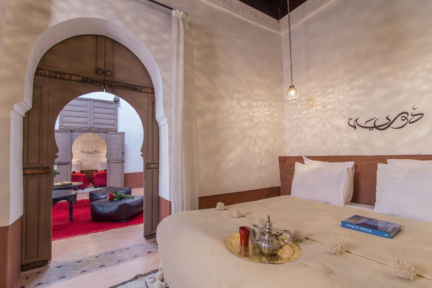 Une chambre de la Suite Douiria ouverte à travers ses arches sculptées